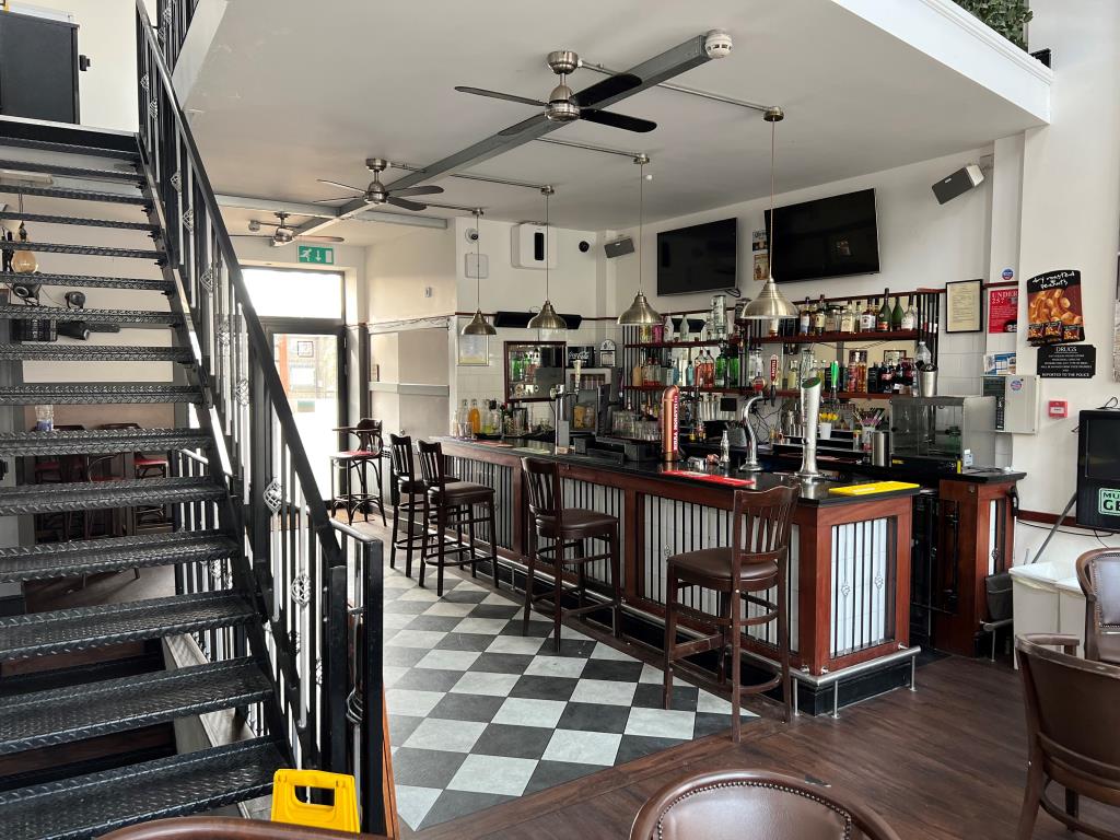 Lot: 173 - TOWN CENTRE FREEHOLD THREE STOREY BAR WITH GARDEN AND PARKING - The ground floor bar area from the front